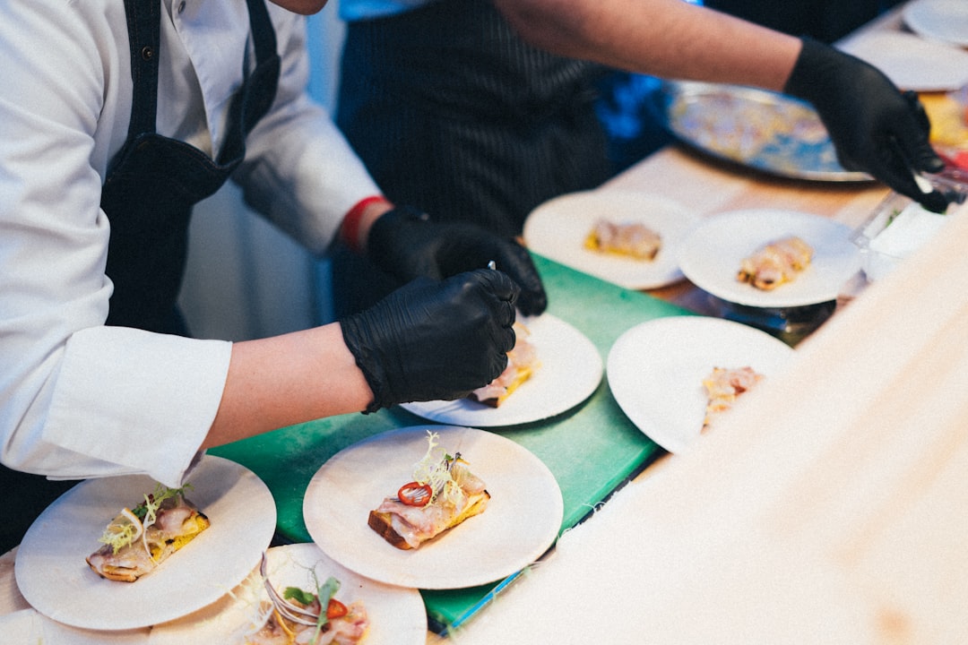 Chef hands plating gourmet dish in professional kitchen